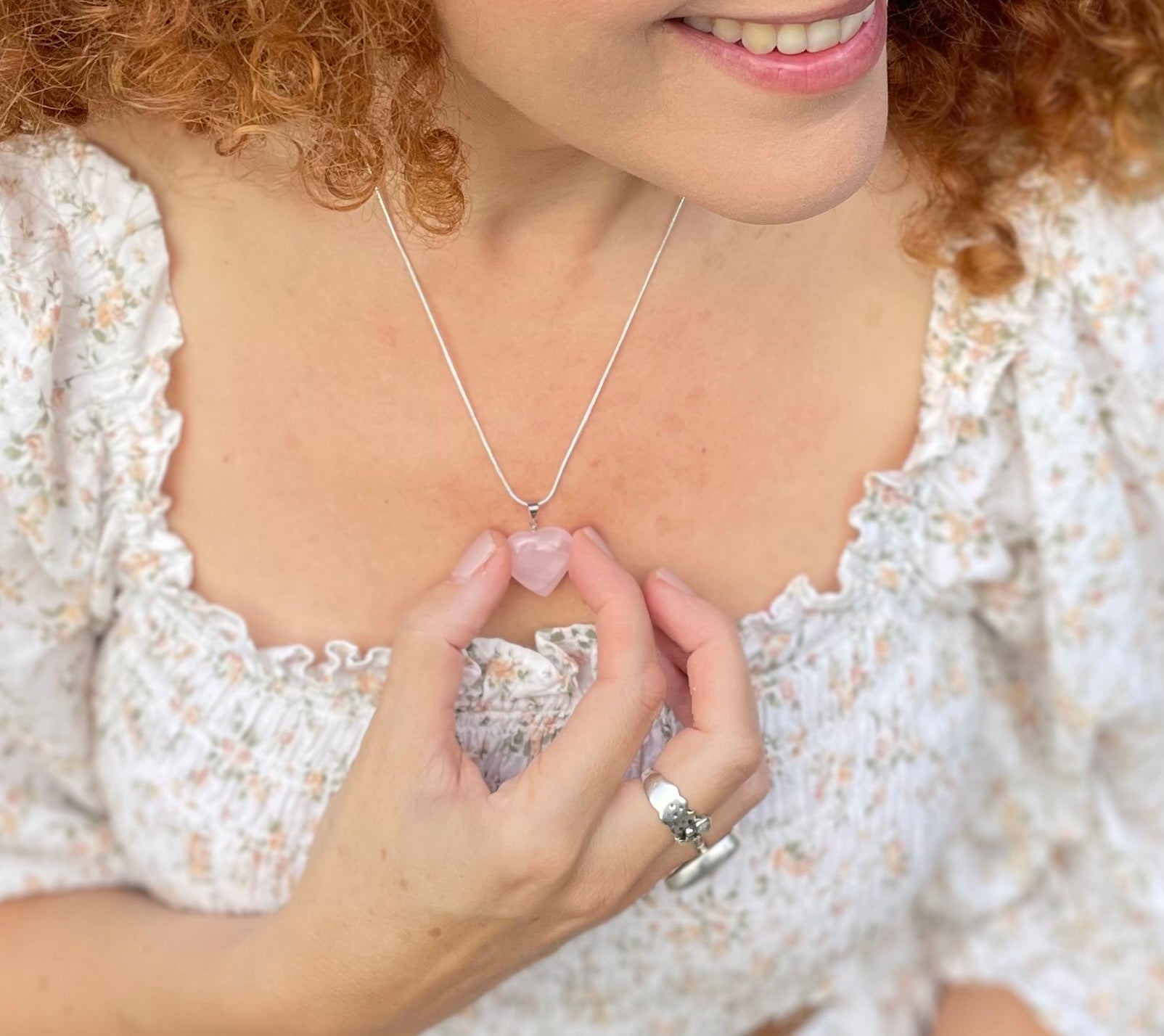 Model wearing rose quartz heart necklace on a chain