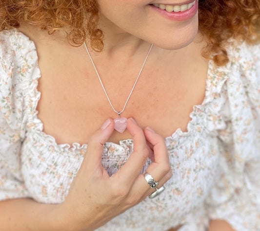 Model wearing rose quartz heart necklace on a chain