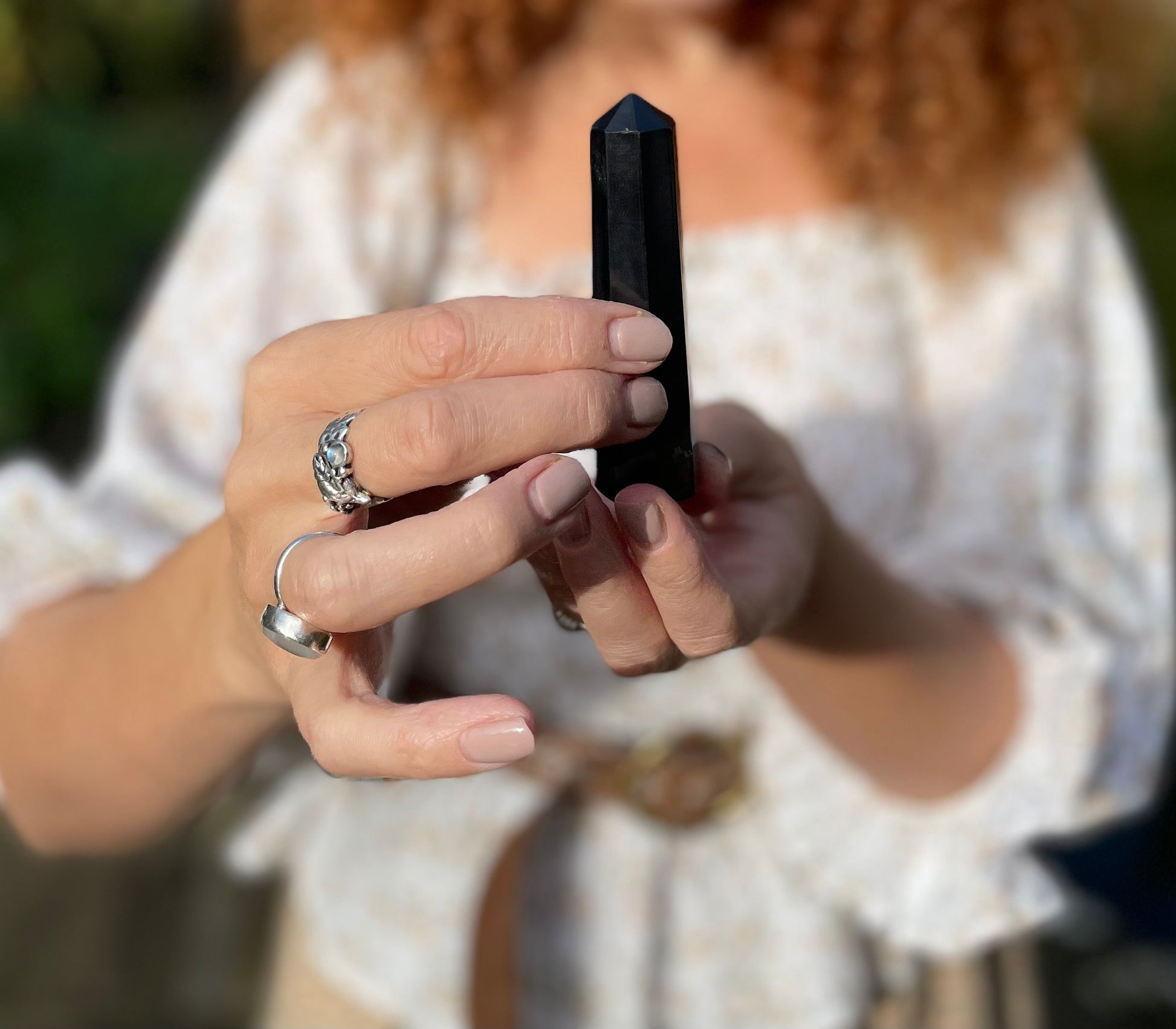 Model holding shungite black polished obilisque