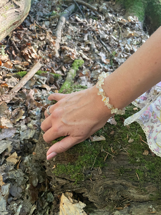 Yellow sunny crystal elasticated bracelet shown on models arm and you can see edge of her floaty sleeve. Pictured in the woods.